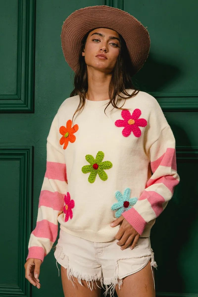Colorful floral sweater for women with vibrant flowers and pink striped sleeves, perfect for spring wear
