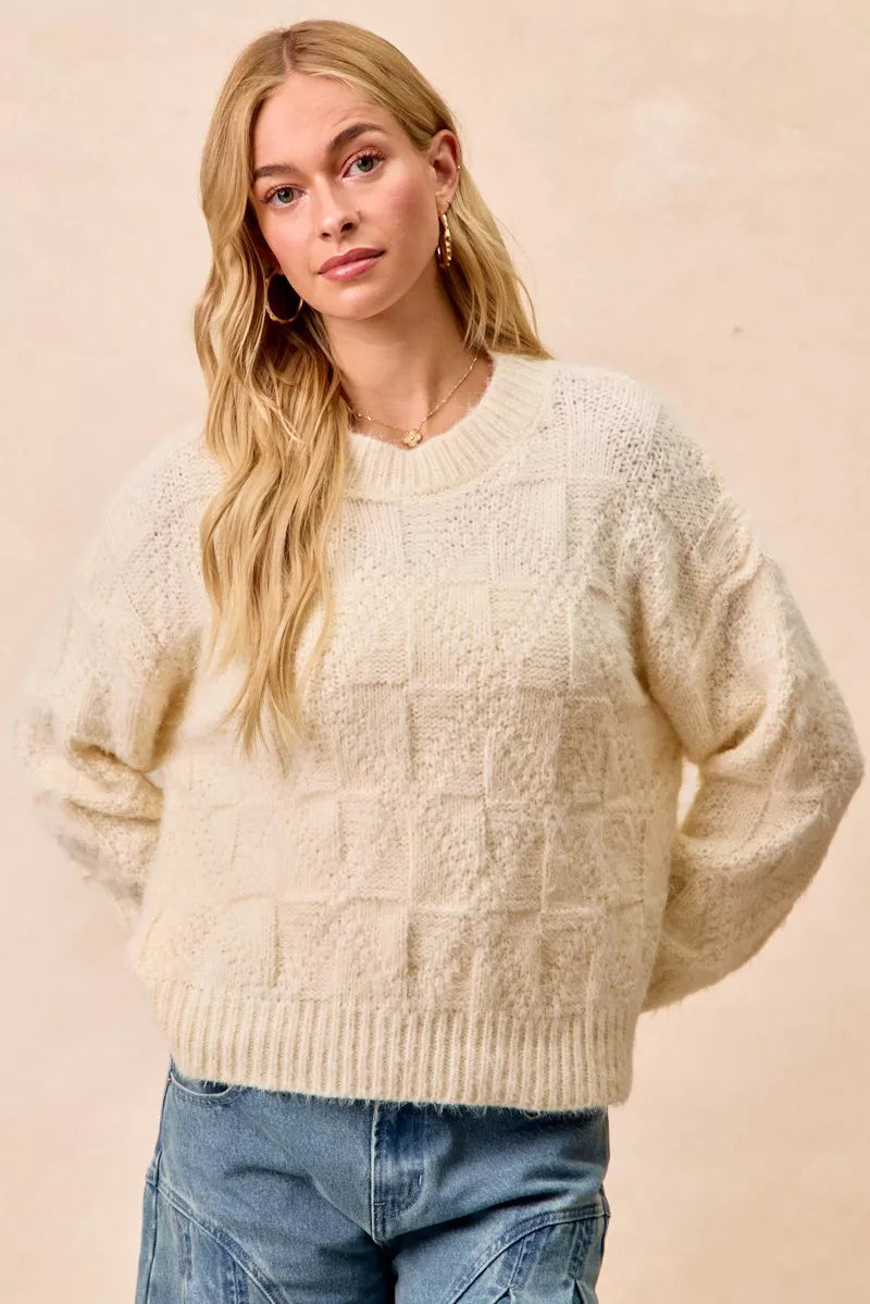 Cream checker board drop shoulder sweater with a cozy knit texture for casual outfits