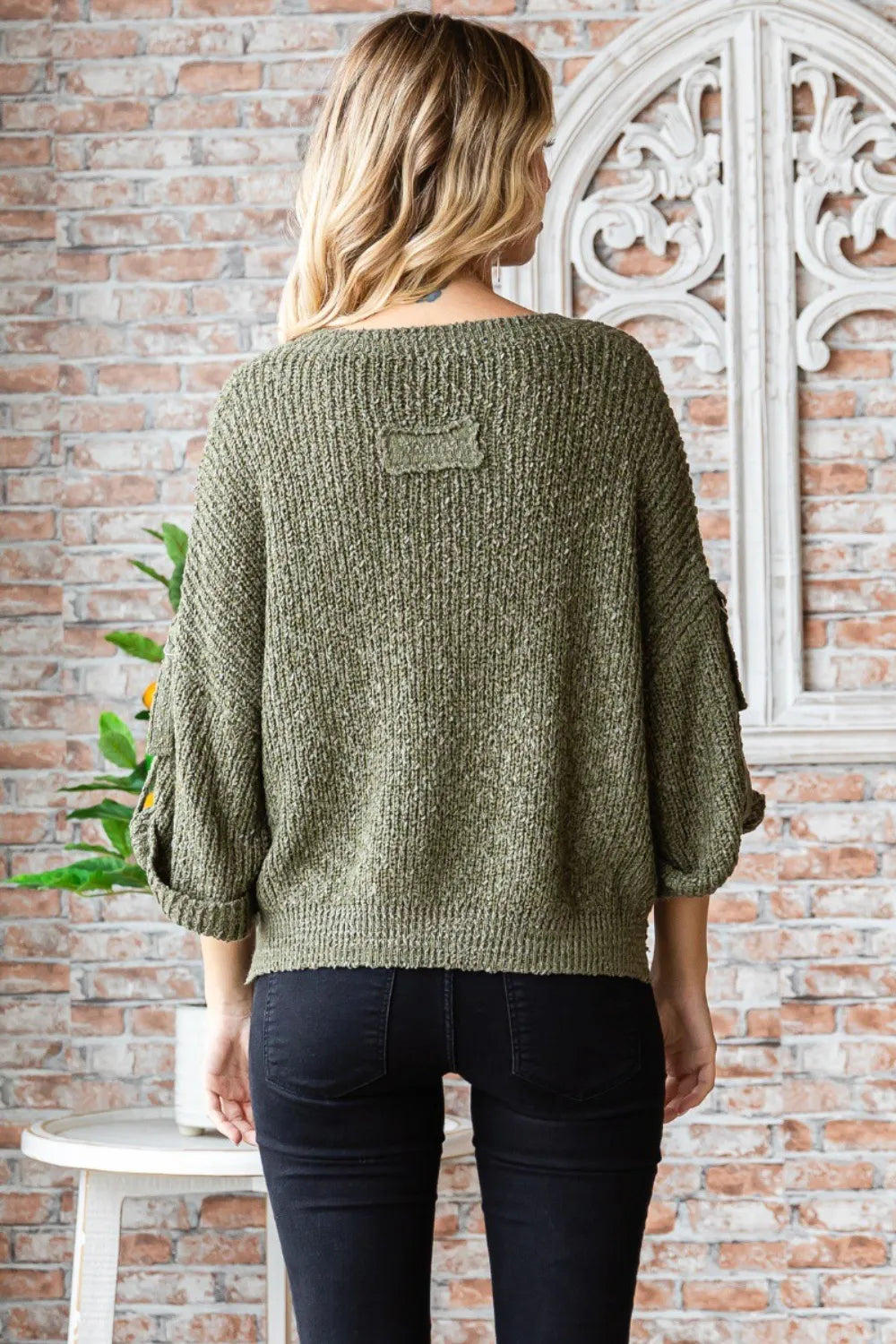 Back view of a boho round neck sweater in olive green with loose sleeves and textured knit pattern