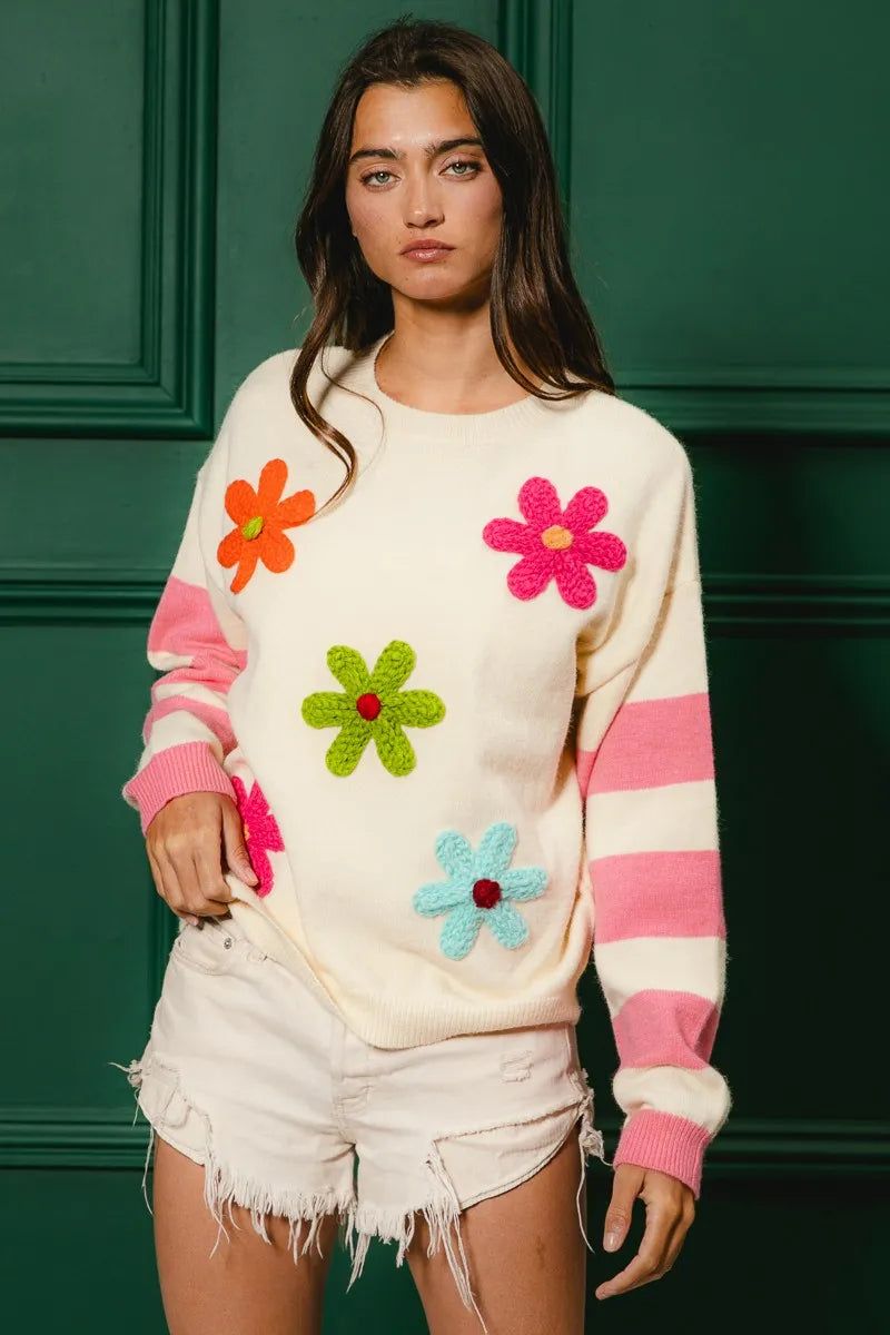 Colorful floral sweater for women with bright flowers and striped sleeves, perfect for a trendy look
