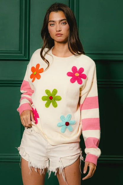 Colorful floral sweater for women with bright flowers and striped sleeves, perfect for a trendy look