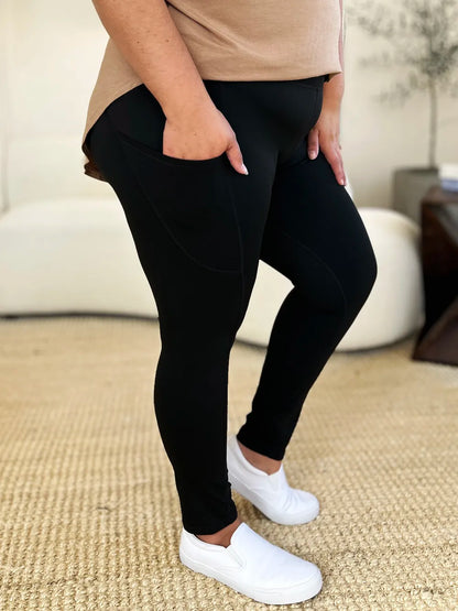 Comfortable black wide waistband sports leggings with pockets, perfect for workouts and everyday wear