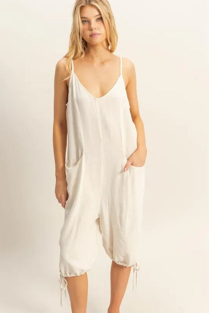 Trendsi boho v-neck romper with pockets in cream featuring relaxed fit and adjustable drawstring hem