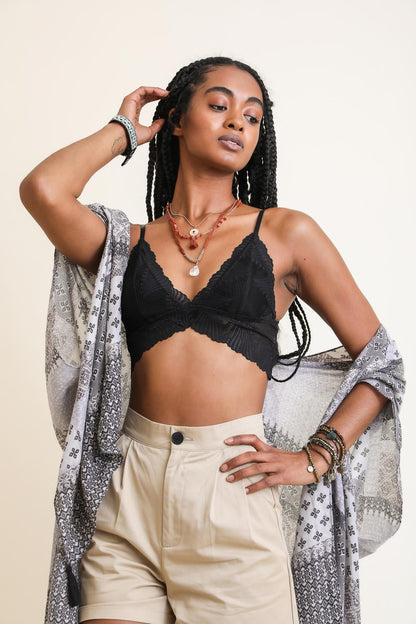 Model wearing a black boho lace bralette paired with stylish shorts and a patterned wrap