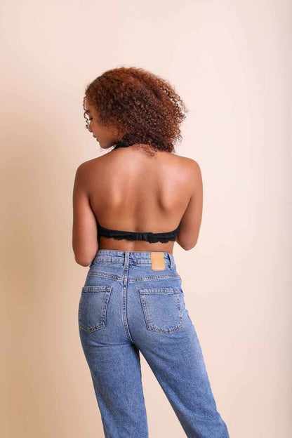 Model wearing a floral lace halter bralette paired with high-waisted jeans from Leto Collection