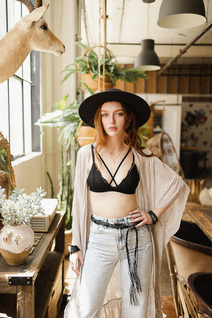 Model wearing a boho cross strap lace bralette styled with a kimono and wide-brimmed hat