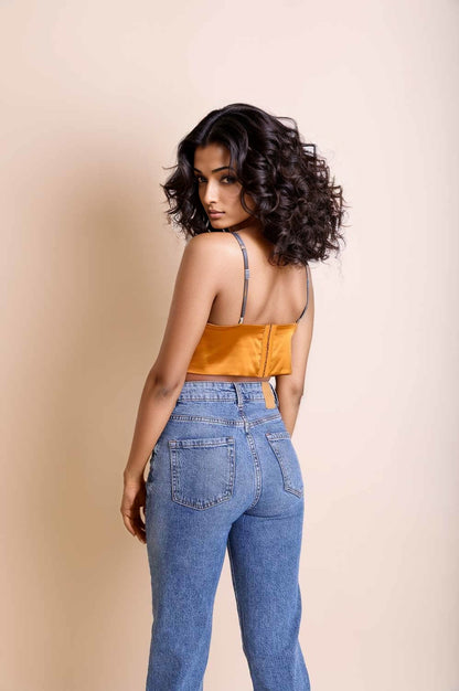 Leto Collection satin longline bralette in mustard, paired with high-waisted denim jeans