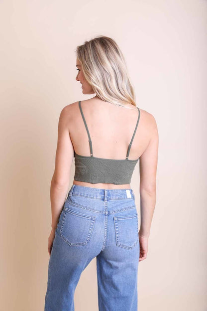 Back view of a woman wearing a green stretchable brami top for women paired with high-waisted jeans