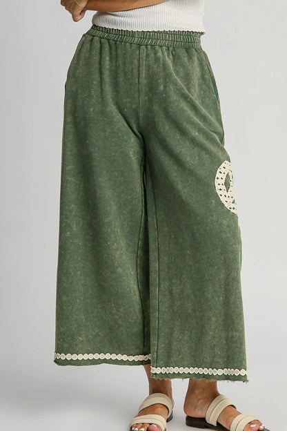 Plus size boho wide leg pants in green with an elastic waistband and lace trim details