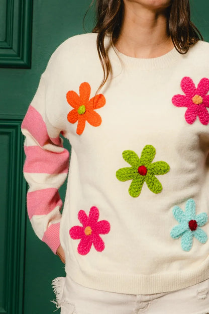 Colorful floral sweater for women featuring bright flowers and striped sleeves
