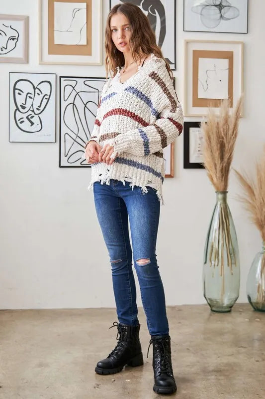 Boho striped frayed edge sweater in cream with blue and rust stripes, styled with skinny jeans and combat boots