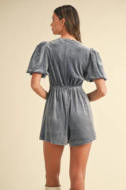 Back view of a gray velvet bow romper for women with puff sleeves and elastic waistband