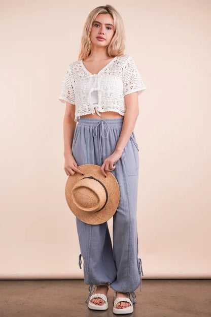 Trendsi crochet front tie crop top paired with stylish light blue pants and a straw hat