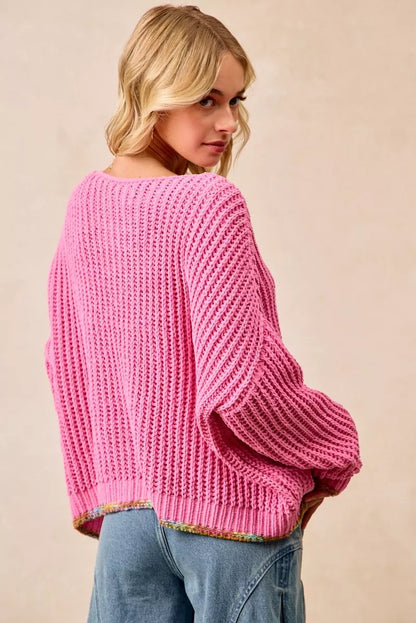 Women wearing a pink boho v-neck sweater with a relaxed fit and chunky knit design