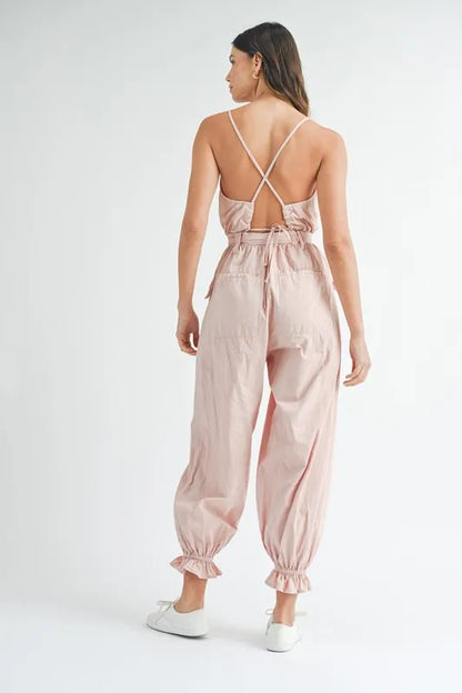 Back view of a boho belted jumpsuit for women in pink with a stylish open back design