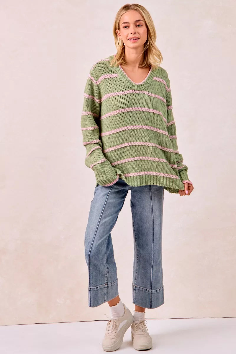 Boho striped long sleeve sweater in green with pink stripes, paired with cropped jeans and sneakers