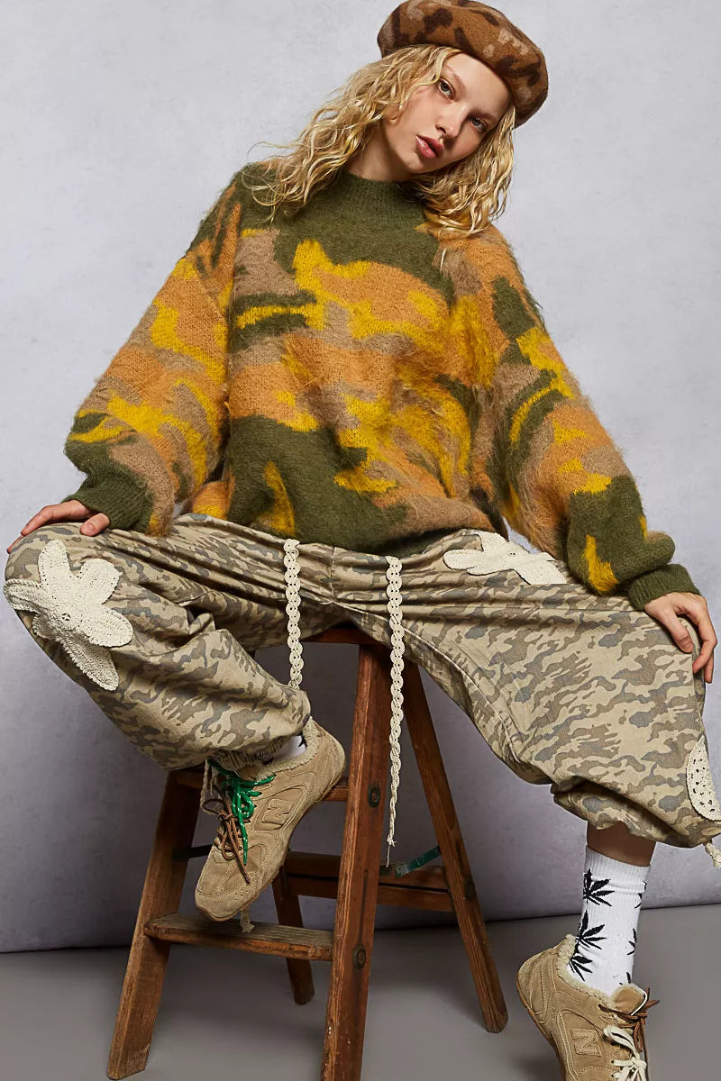 Abstract colorblock sweater women in green and orange tones paired with camo pants for a trendy look
