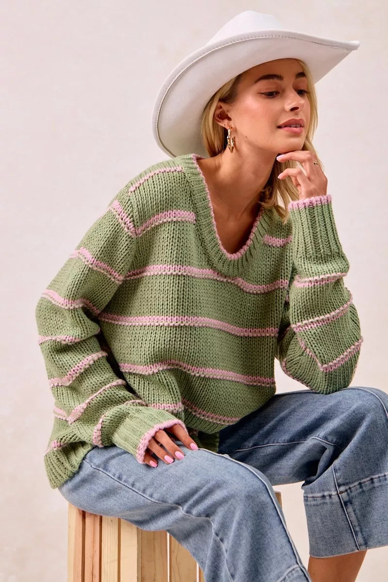 Boho striped long sleeve sweater in green and pink, worn with jeans and a wide-brimmed hat