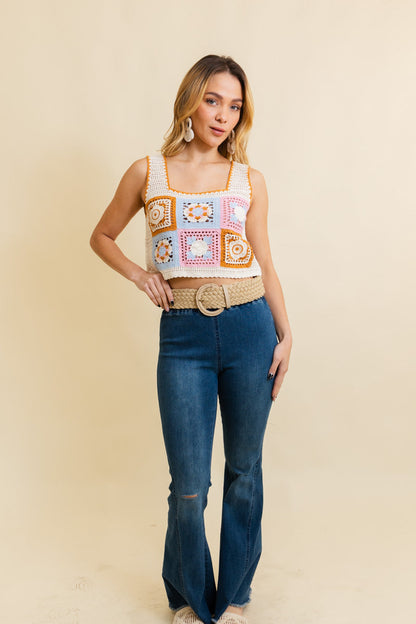 Model wearing a boho woven raffia belt styled with a cropped top and flared jeans