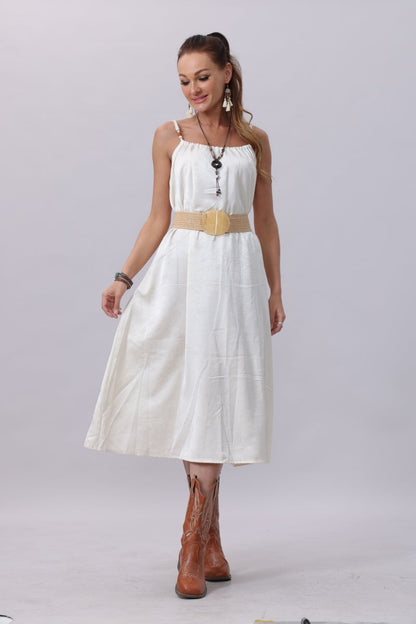 Woman wearing a white dress with a boho woven belt with buckle and brown cowboy boots