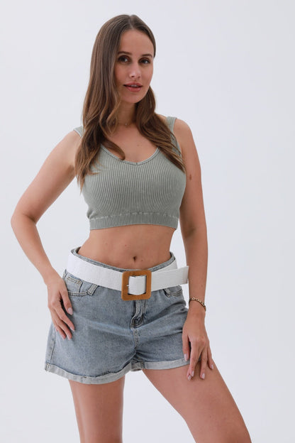Fashionable model wearing a boho woven raffia belt with a white finish and oversized buckle over denim shorts