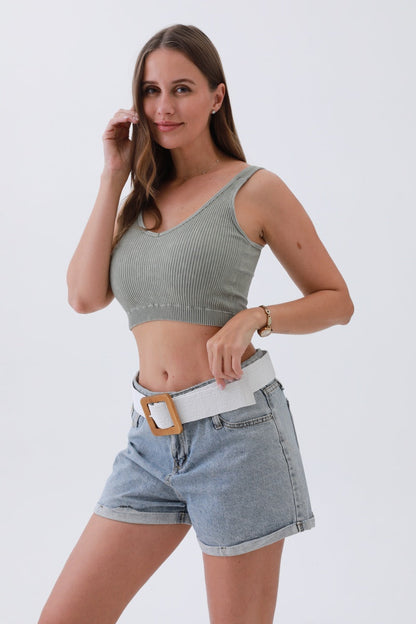 Fashion model wearing a boho woven raffia belt with a white and beige design over denim shorts