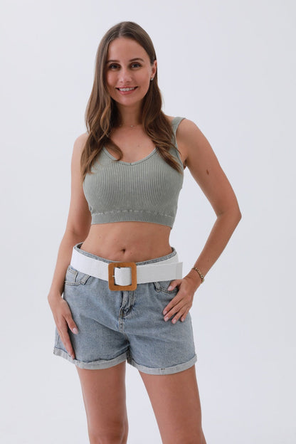Model wearing a boho woven raffia belt with high-waisted denim shorts and a cropped top