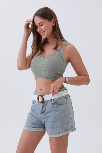 Stylish model wearing a minimalist boho raffia belt with casual denim shorts and a ribbed crop top