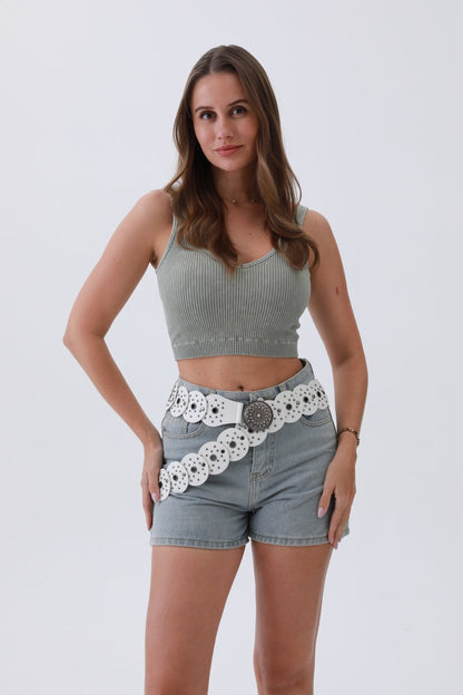 Model wearing an edgy hollow-out belt paired with denim shorts and a ribbed top for a trendy look