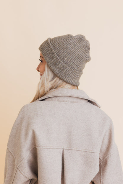 Woman wearing a stylish eco friendly knit beanie in light gray for a cozy and sustainable look