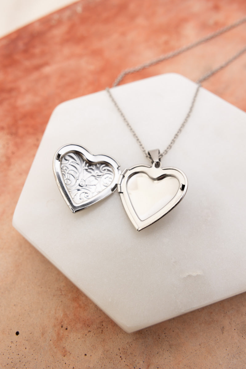 Silver heart locket necklace open with engraved interior on white marble display Boho Necklace, Boho Chic Jewelry, Spiritual