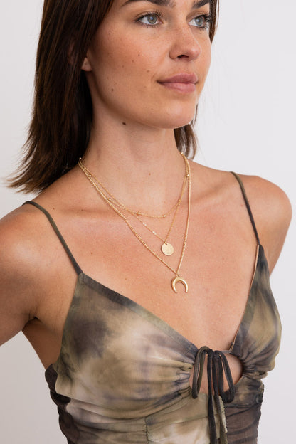 Leto Collection Boho Necklace layered with gold chains, featuring a crescent pendant, ideal for Boho Chic Jewelry enthusiasts.