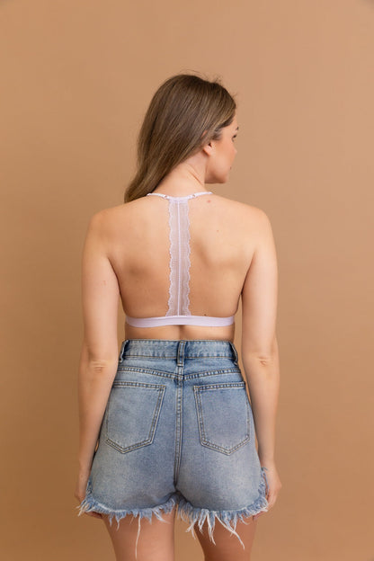 Leto Collection lace t-back bralette in soft lavender worn with high-waisted denim shorts