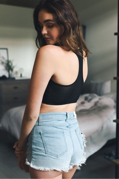 Leto Collection boho mesh bralette in black styled with high-waisted denim shorts for a casual look