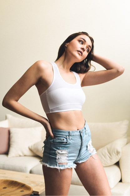 Leto Collection boho mesh bralette worn by a model with denim shorts in a stylish indoor setting
