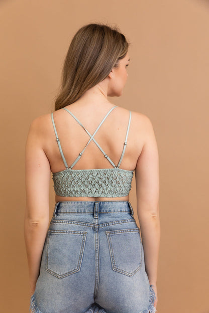 Back view of Leto Collection boho crochet lace bralette in green paired with high-waisted denim shorts