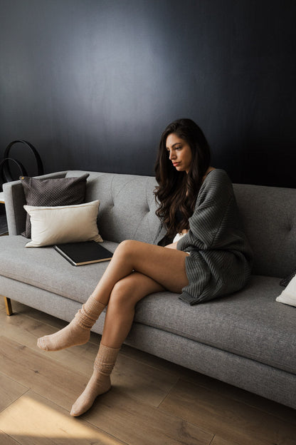 Leto Collection slouchy knit socks for women showcased on a model sitting on a couch