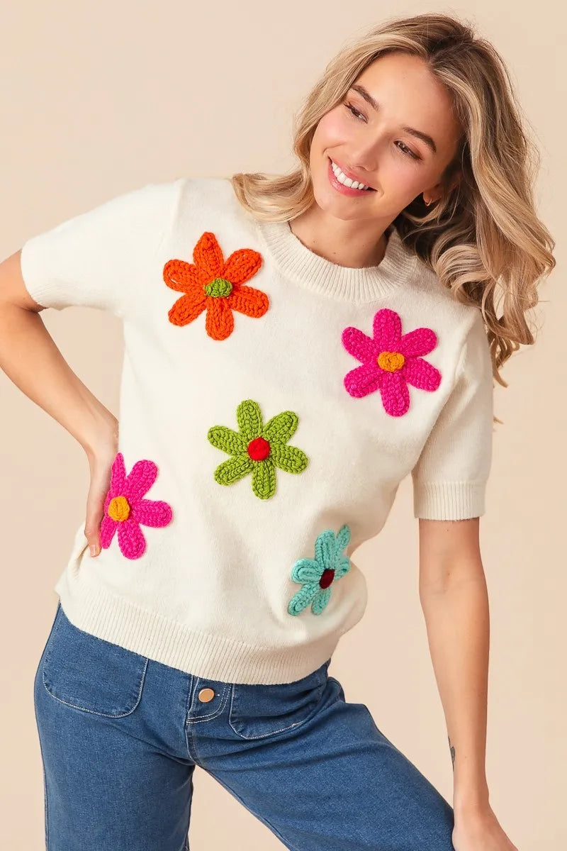Trendsi crochet flower sweater top featuring colorful floral appliques on a cream background