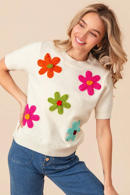 Trendsi crochet flower sweater top featuring colorful floral appliques on a cream background