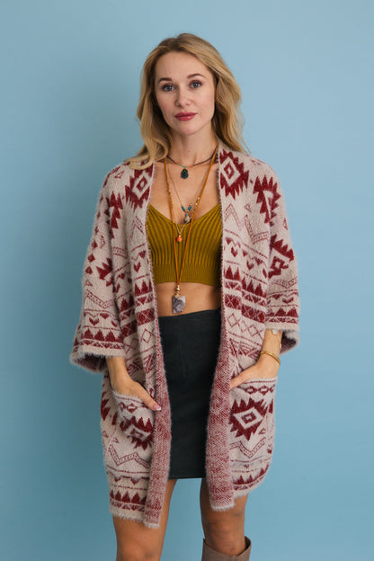 Model wearing an Aztec print knit cardigan with pockets over a green top and black skirt