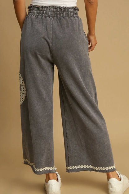 Back view of plus size boho wide leg pants in gray with decorative details