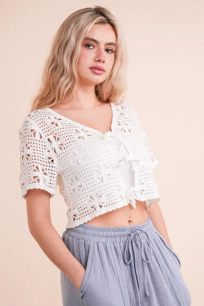 White crochet front tie crop top featuring floral patterns and short sleeves for a stylish summer look