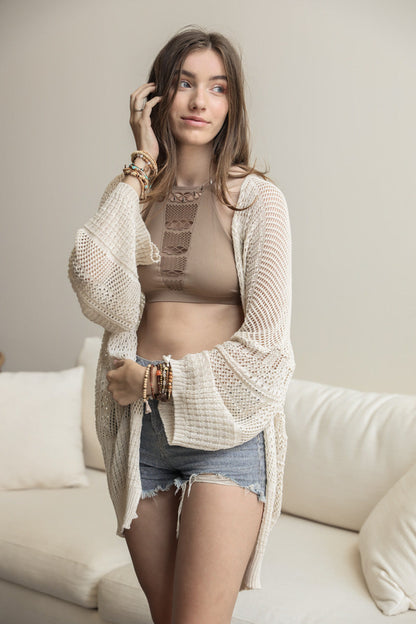 Leto Collection boho knit netted cardigan in cream, styled with a crop top and shorts for a chic look