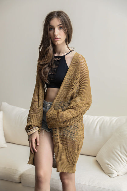 Leto Collection boho knit netted cardigan in mustard color over a black top and shorts