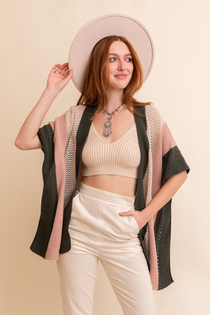 Leto Collection boho knit poncho for women in shades of pink and green, styled with a hat