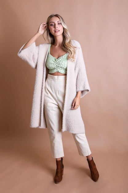 Leto Collection boho mohair knit cardigan in light pink worn over a green crop top and cream trousers