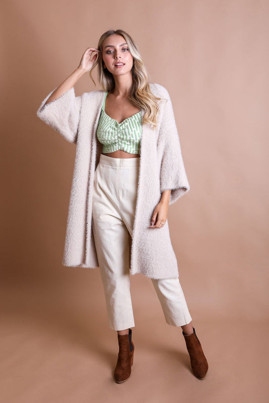 Leto Collection boho mohair knit cardigan in light pink worn over a green crop top and cream trousers