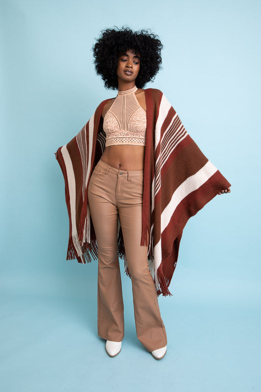 Leto Collection boho striped ruana in earthy tones, stylishly worn over a crop top and flared pants