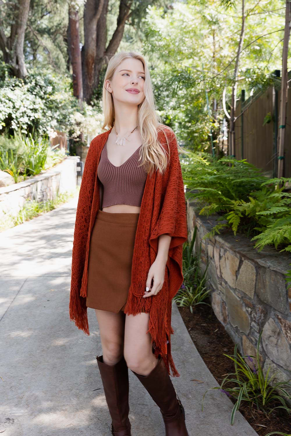 Leto Collection boho tassel wrap in rust color styled with a brown crop top and skirt