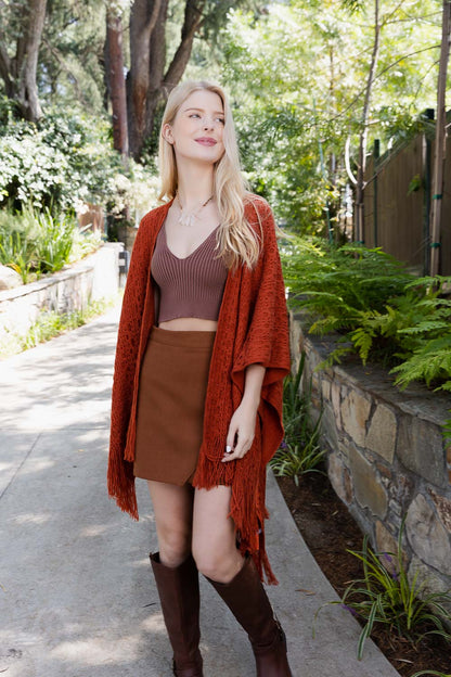 Leto Collection boho tassel wrap in rust color styled with a brown crop top and skirt
